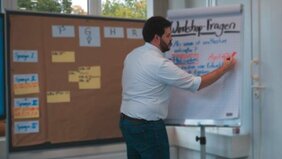 Mitarbeiter der Firma Kapp Niles beschriftet ein Flipchart in einem Schulungsraum