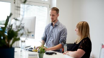 Eine Mitarbeiter und eine Mitarbeiterin der Firma Prodinger in einem modernen Büro