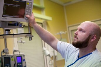 Bärtiger Pfleger im Klinikum Coburg macht Einstellung an einem medizinischen Gerät