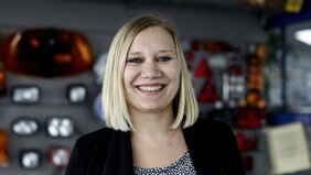 Mitarbeiterin der Firma Leise Coburg vor einer Präsentationswand mit Autoteilen